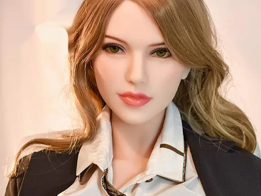Close-up of a realistic doll face with green eyes and auburn hair